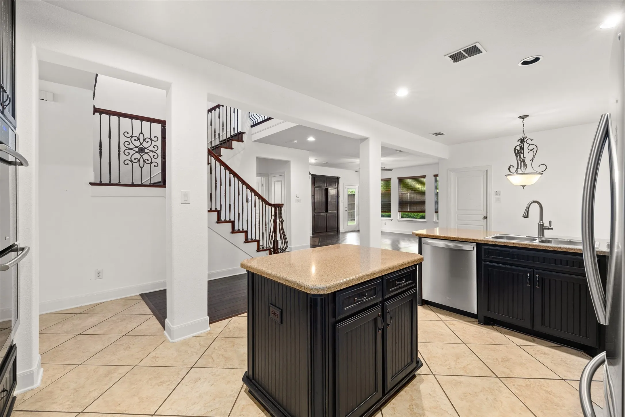 Kitchen featuring a center island, pendant lighting, appliances with stainless steel finishes, sink, and light tile floors