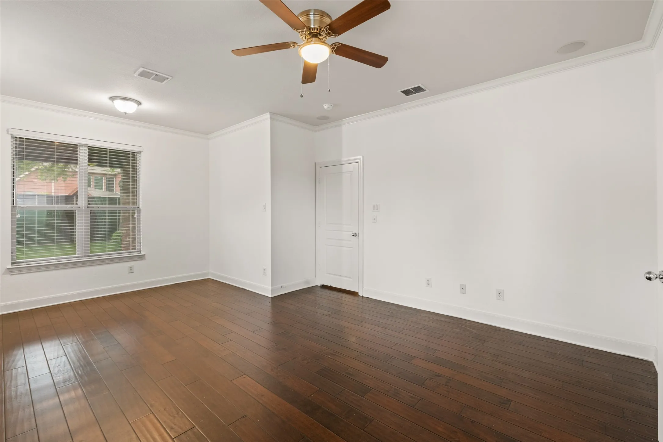 Featuring ceiling fan, crown molding, and dark wood-type flooring