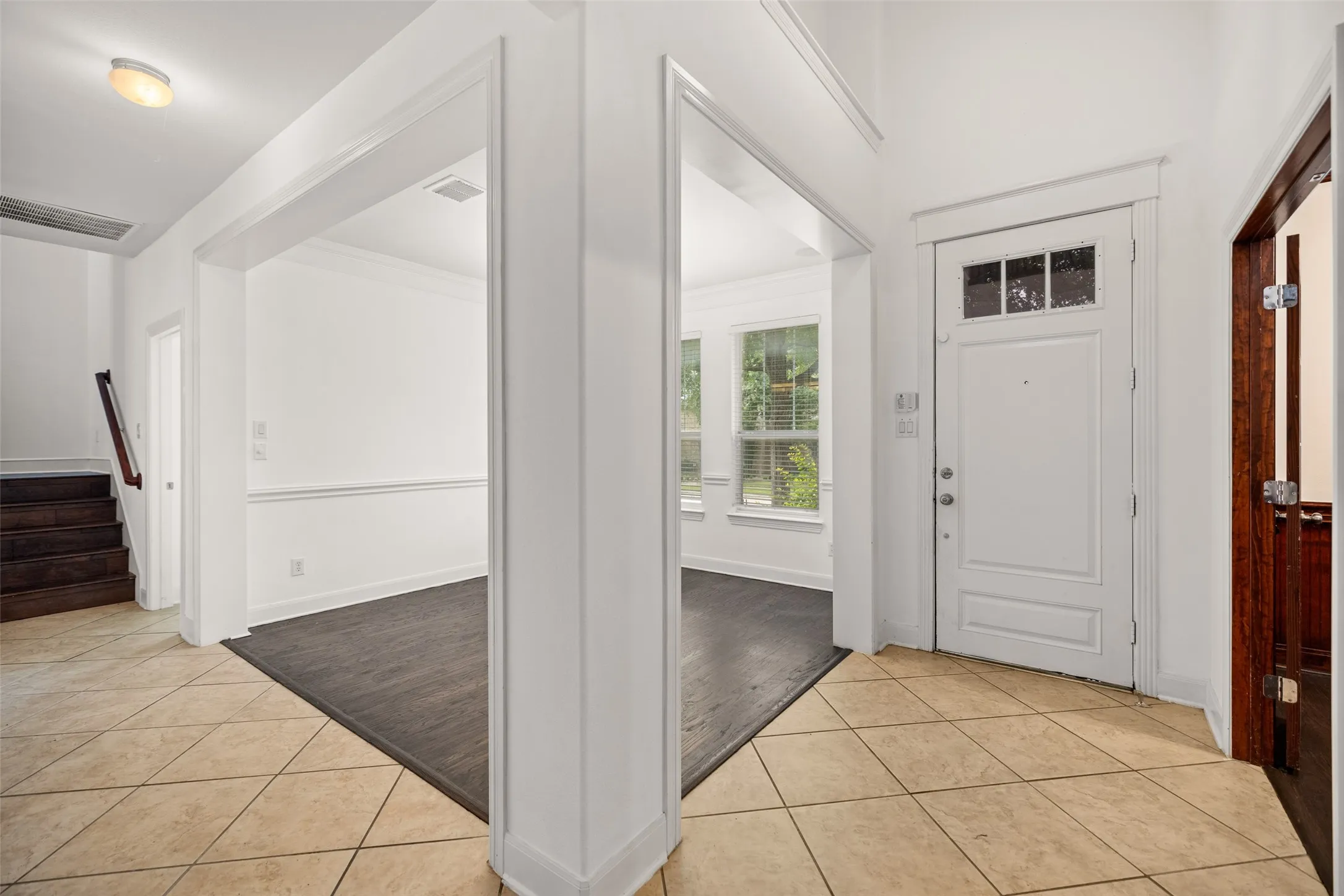 Entryway with light wood-type flooring and ornamental molding