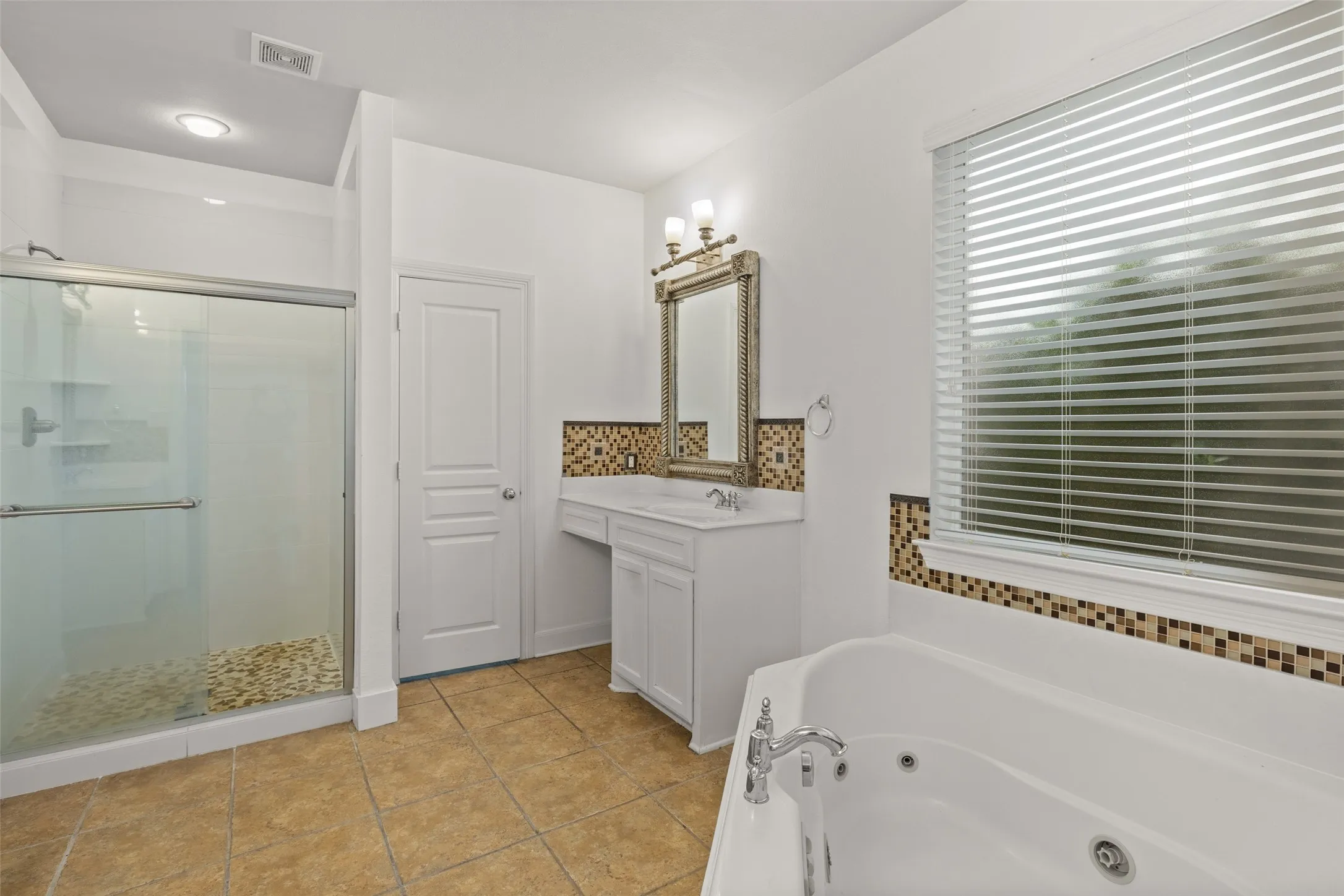 Bathroom featuring vanity, shower with separate bathtub, and tile floors