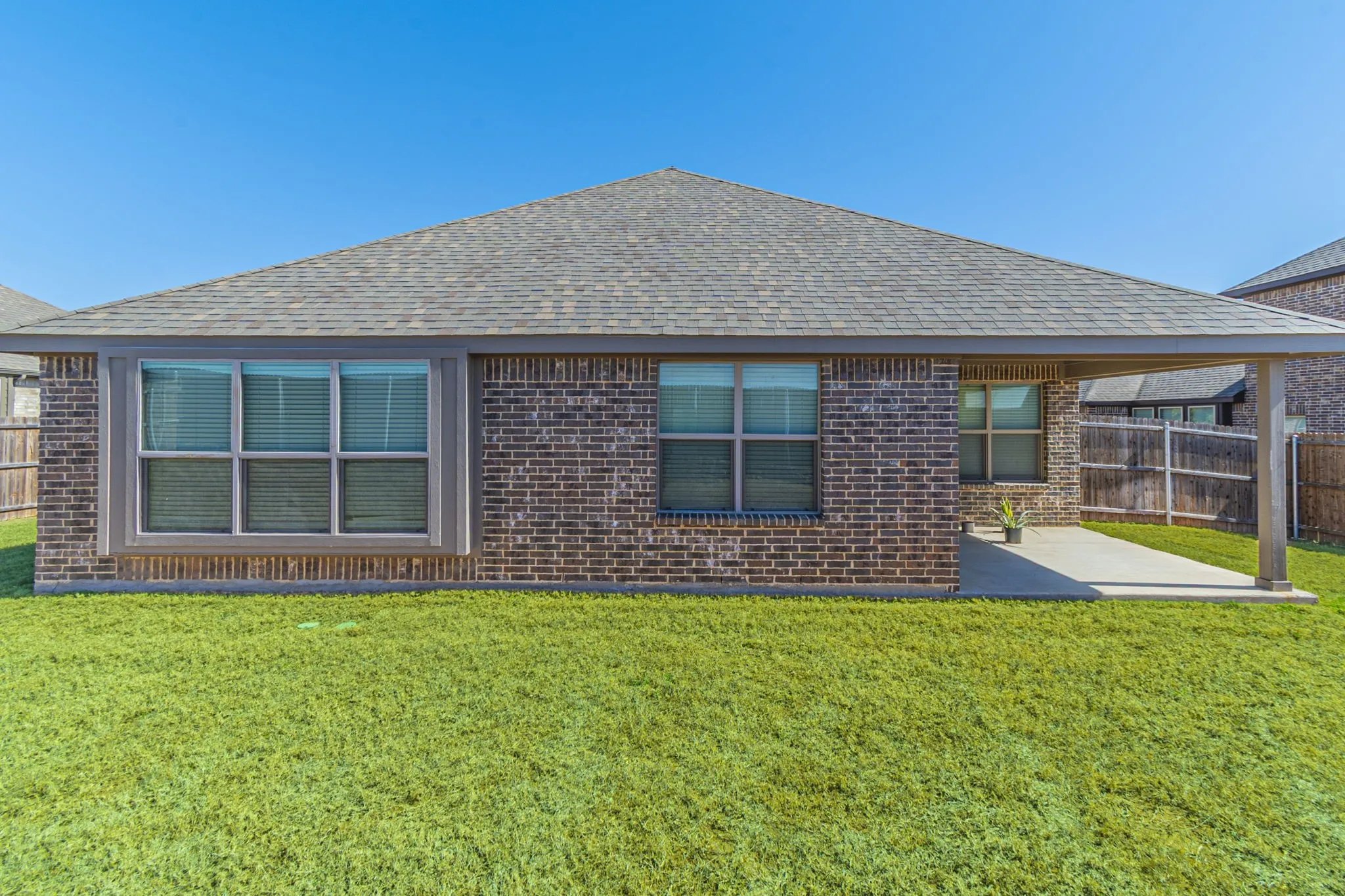 Brick exterior featuring a gabled roof and a covered patio