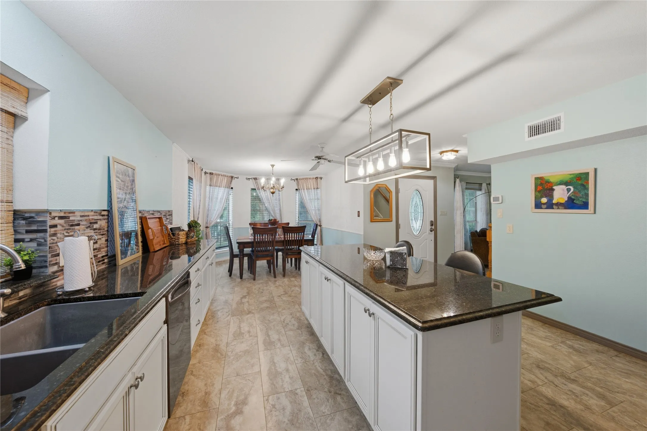 Kitchen featuring granite countertops, white cabinetry, a large kitchen island, mosaic tile backsplash, and wood-finish flooring