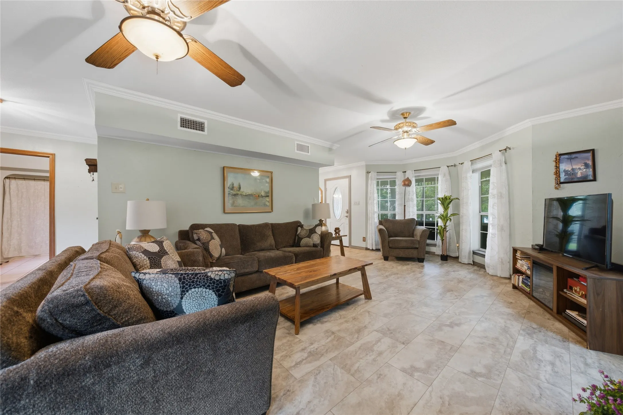Spacious living area featuring light-toned tile flooring throughout