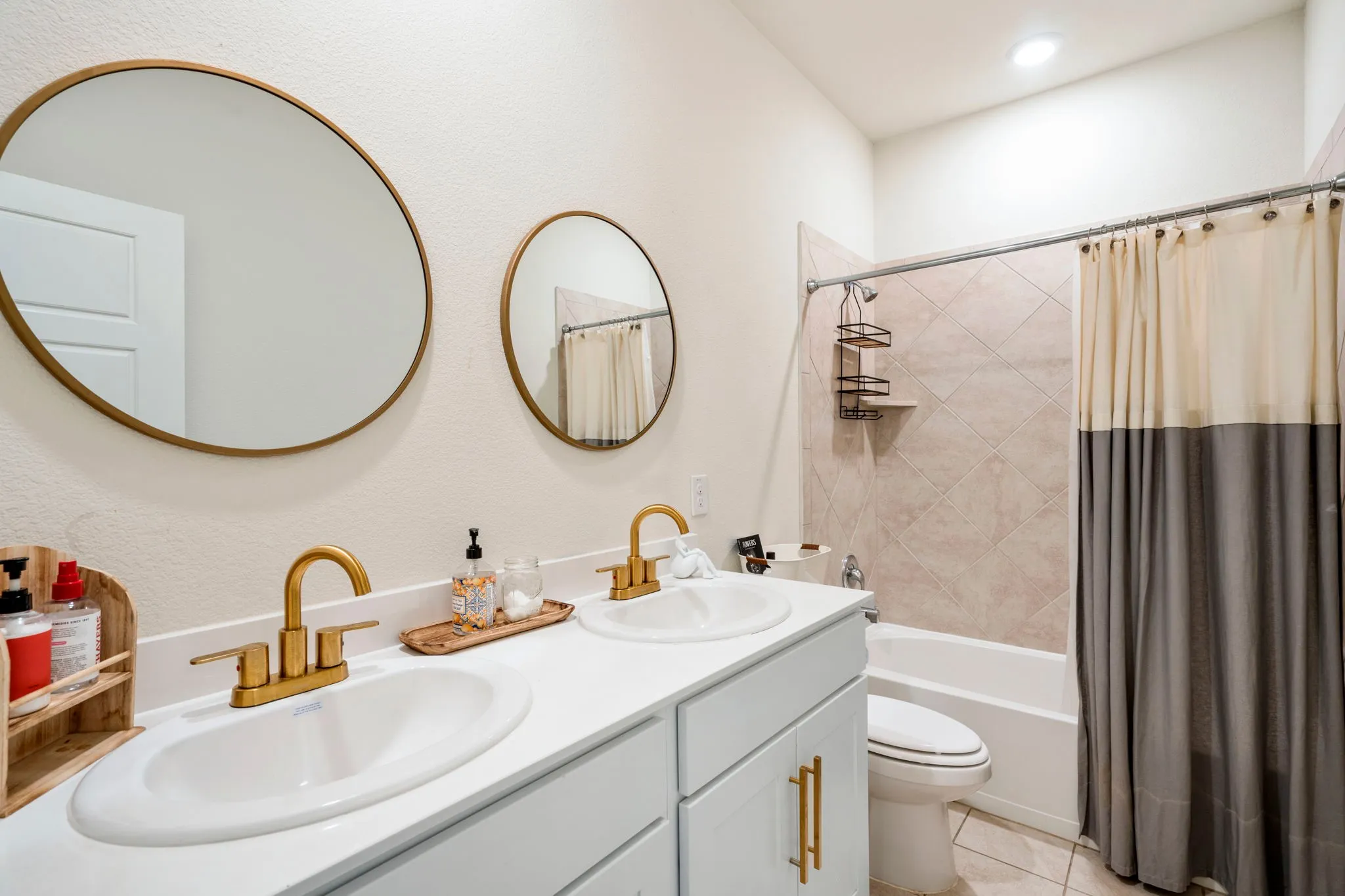 Dual vanity with white undermount sinks and gold-tone faucets set in a white countertop