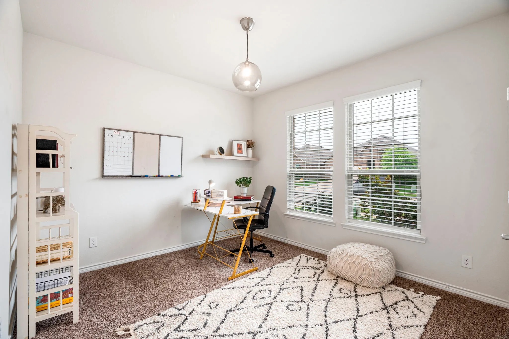 Carpeted room featuring two window units with blinds and a ceiling-mounted light fixture