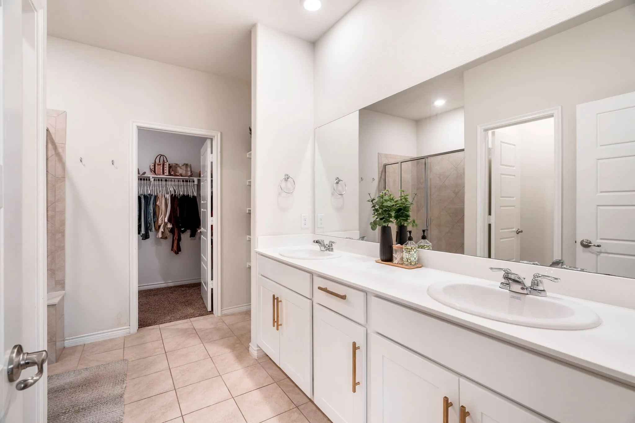 Double vanity with white cabinetry and gold-finish hardware