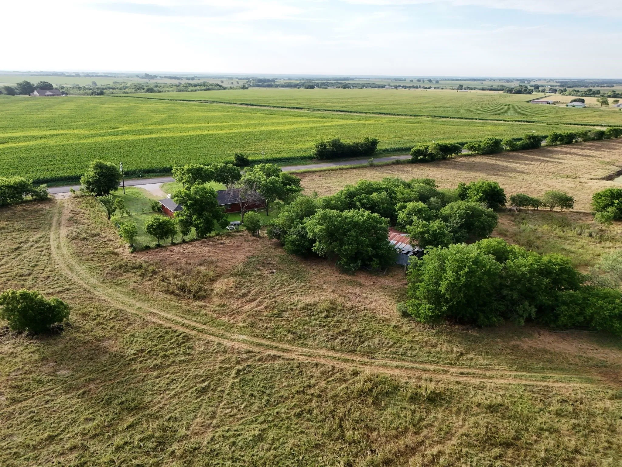 Expansive rural property featuring a main residence, mature landscaping, and surrounding agricultural fields