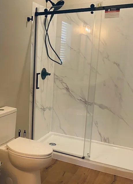 Bathroom with toilet and a marble finish shower