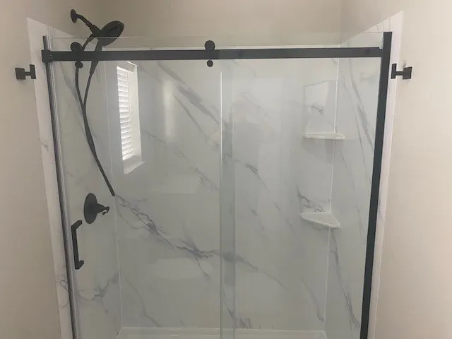 Bathroom featuring a marble finish shower