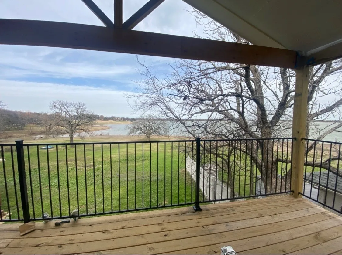 Wooden deck featuring a water view and a yard
