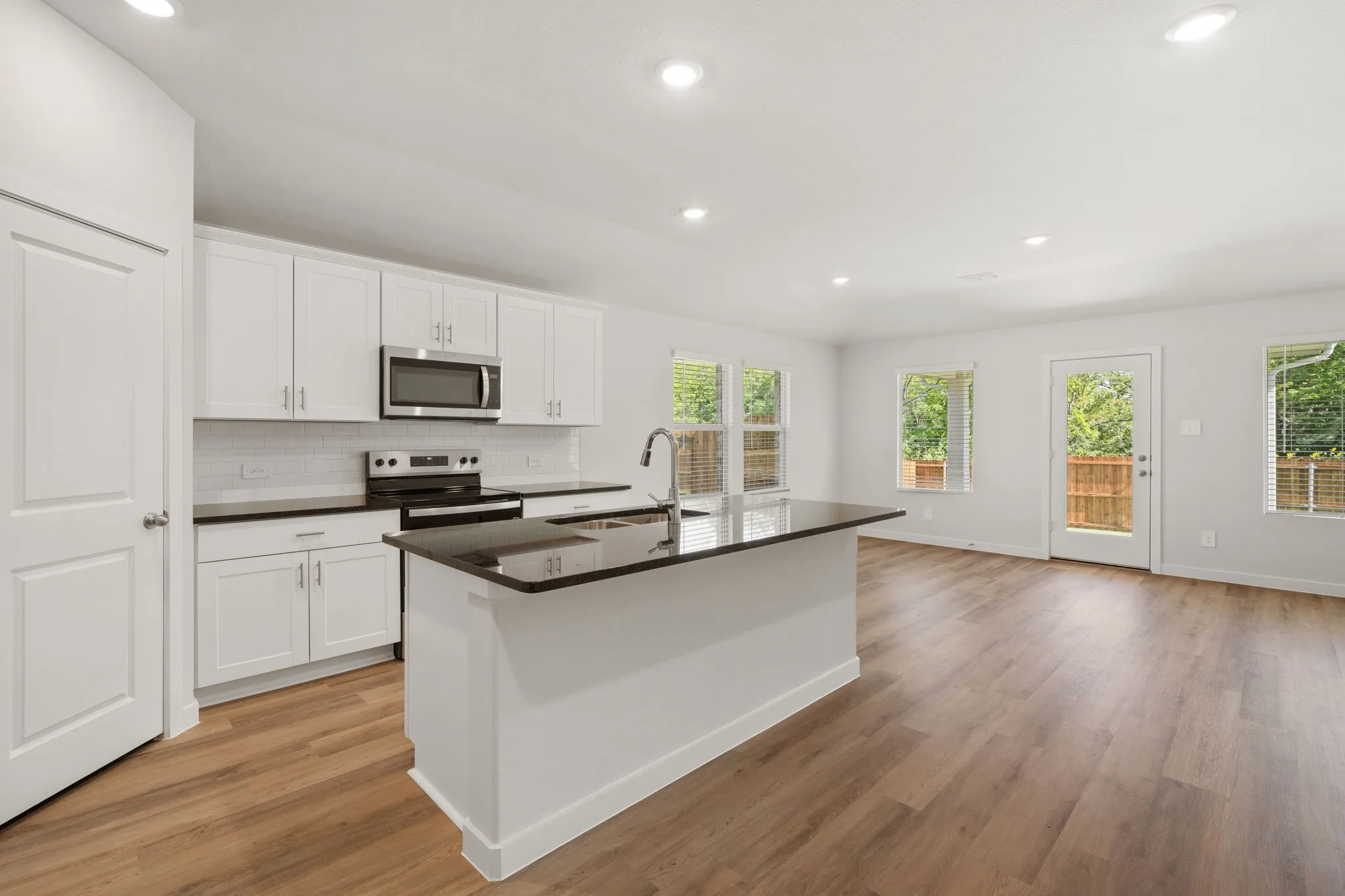 Open-concept kitchen and living area featuring wood-finish flooring