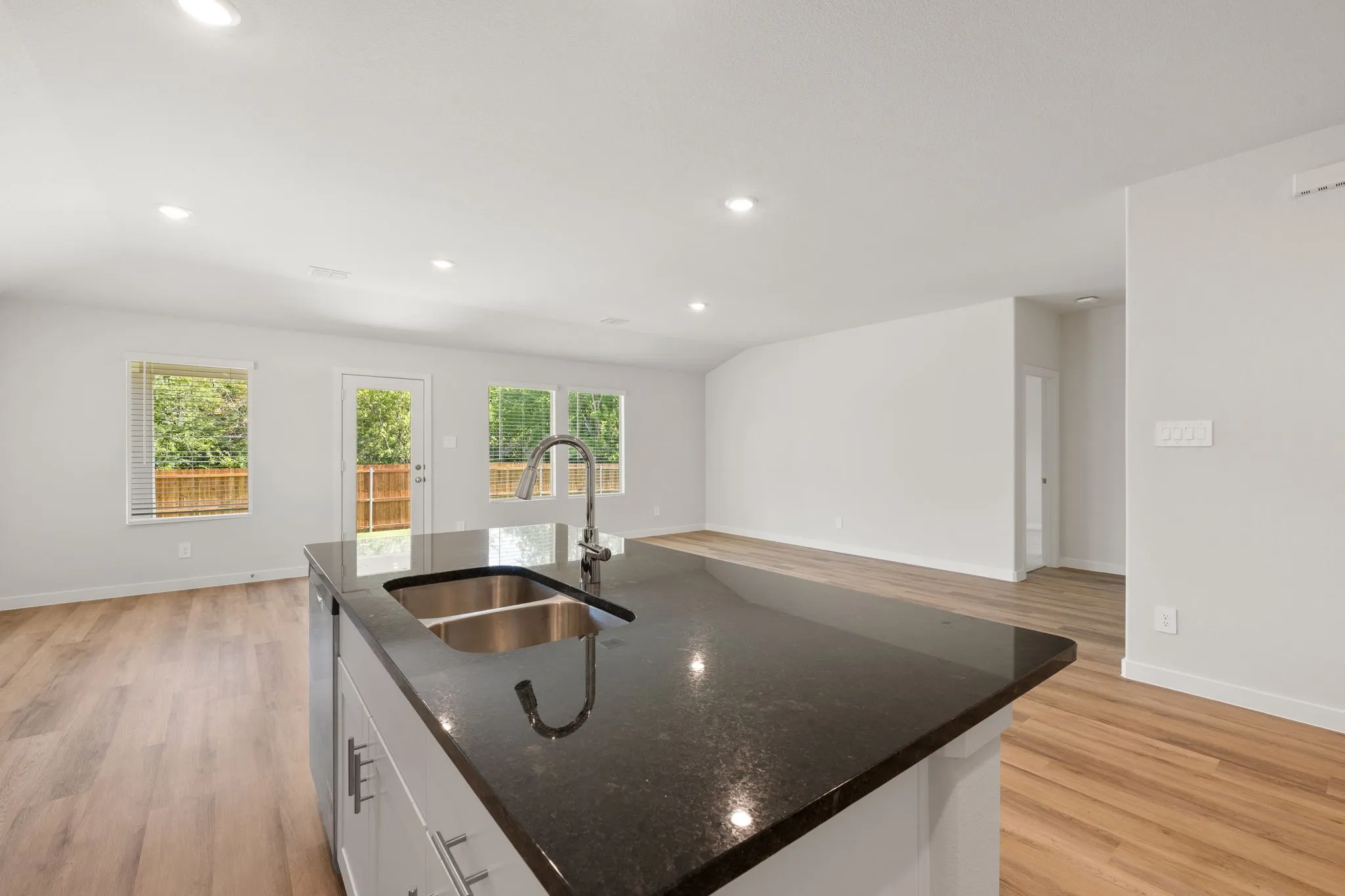 Kitchen island featuring a double basin stainless steel sink and a gooseneck faucet
