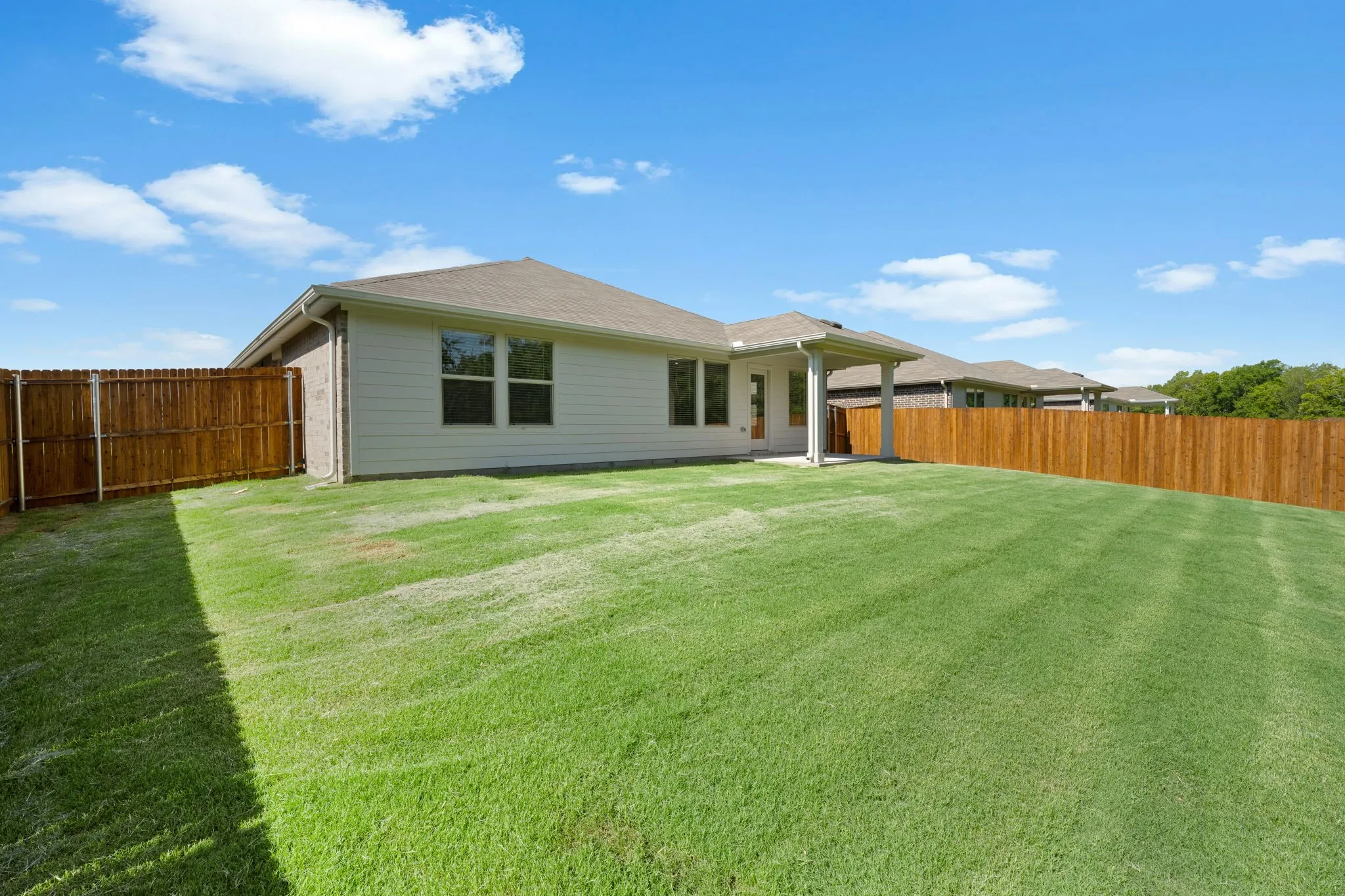 Expansive grass lawn bordered by a wood fence
