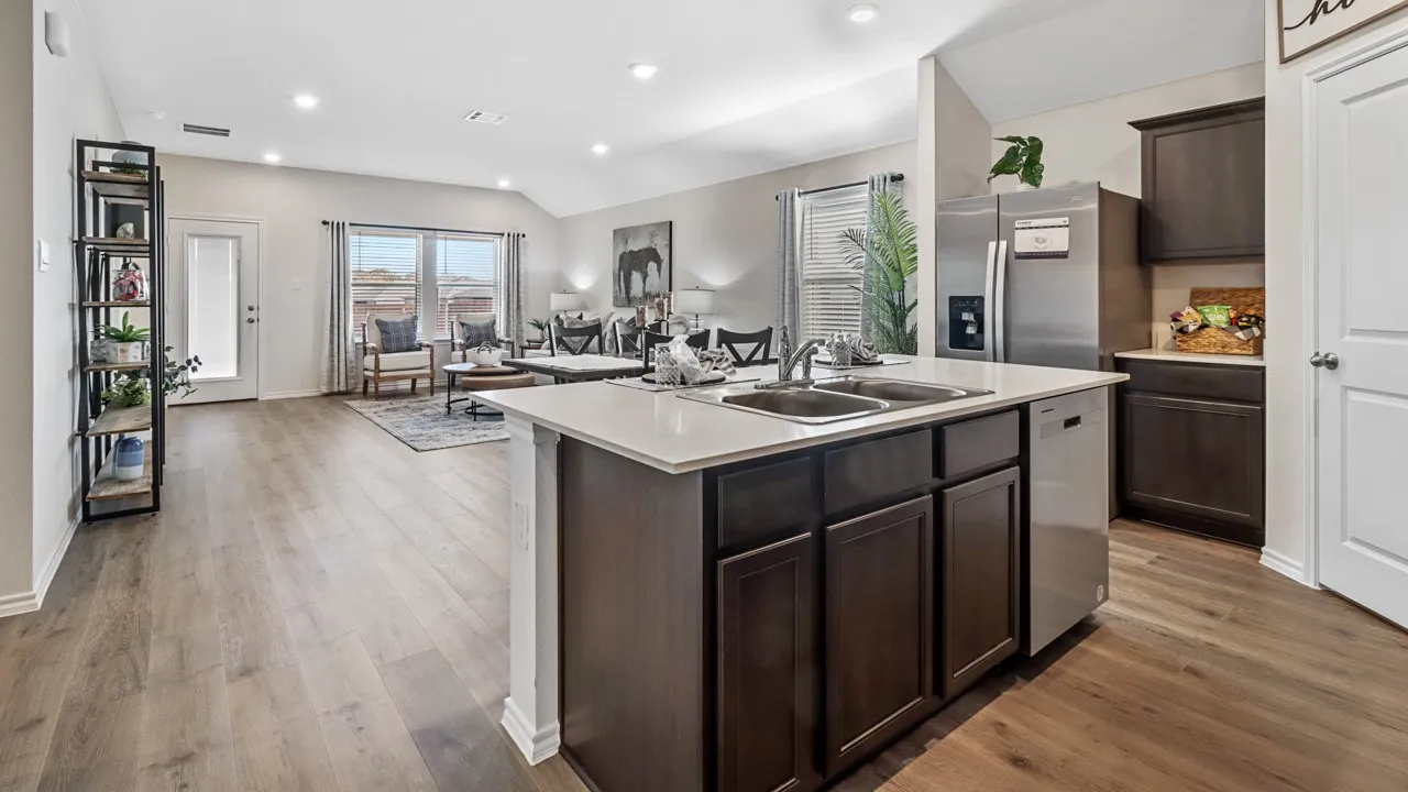 Kitchen island featuring a double-basin sink, stainless steel dishwasher, and quartz countertop