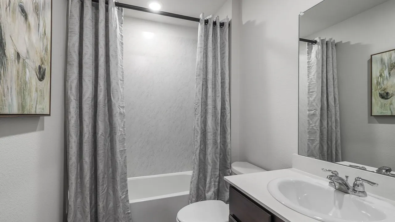 Bathroom featuring a white integrated sink vanity with chrome fixtures and an overhead mirror