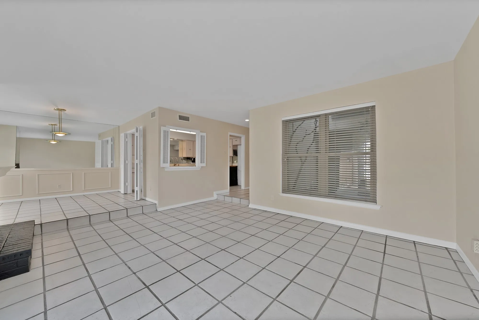 Spacious interior featuring light-toned tile flooring throughout and neutral wall paint