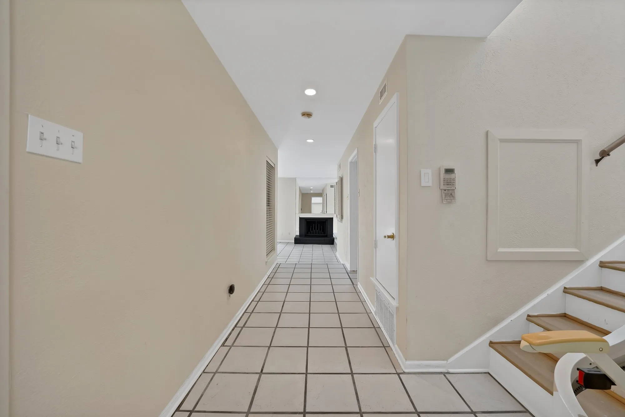 Hallway with square tile flooring, recessed lighting, and light neutral wall finishes