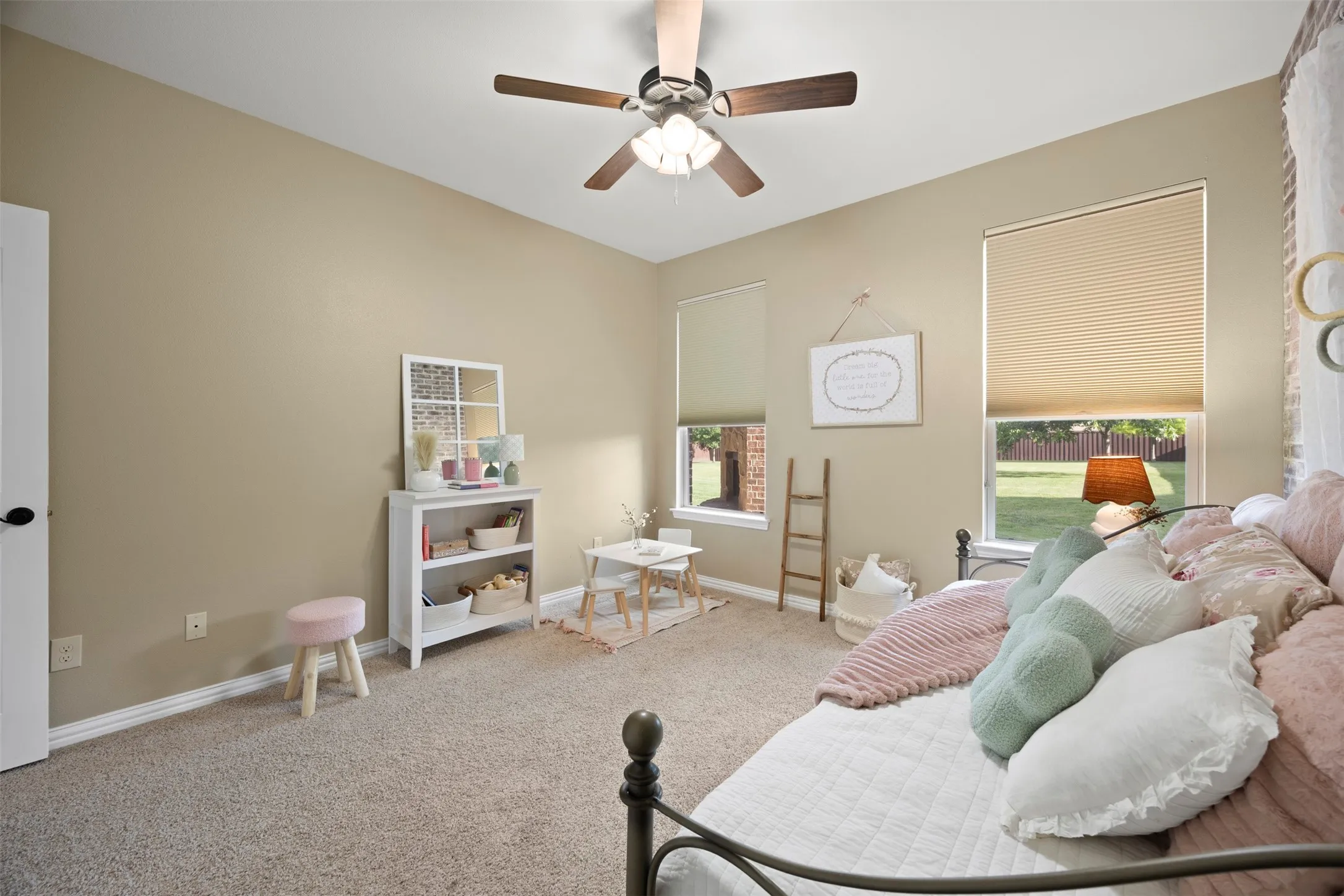 Spacious room featuring vaulted ceilings, a ceiling fan with integrated lighting, and two windows with cellular shades