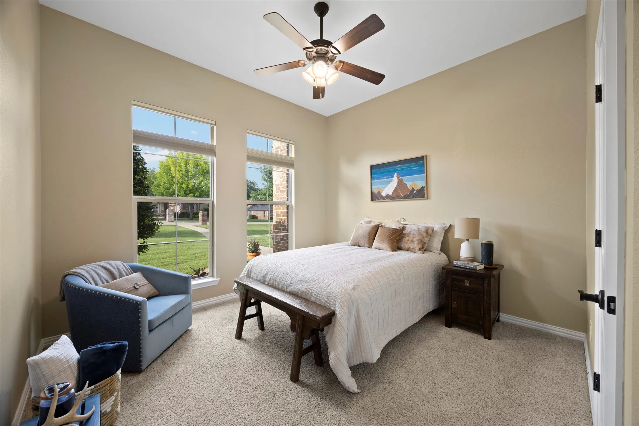 Neutral-toned room featuring a ceiling fan with integrated lighting, two tall windows, and light-colored carpeting