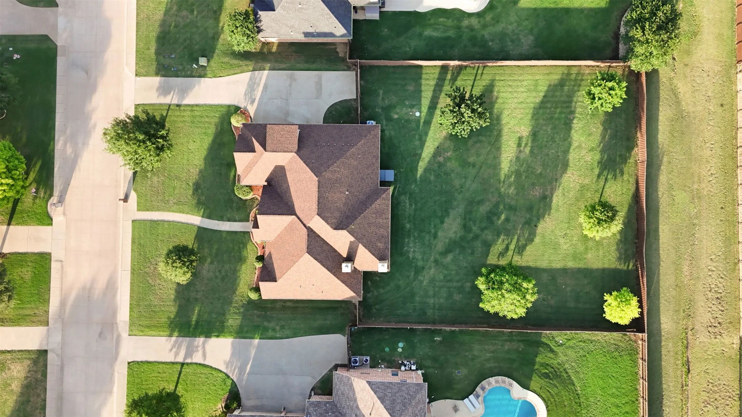 Aerial perspective showcasing a residential property with a multi-gabled roof and a spacious backyard