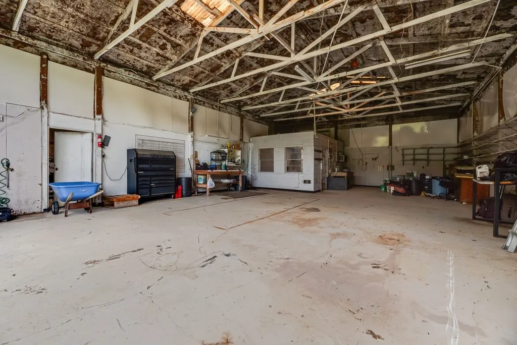 Spacious interior featuring a concrete floor, exposed structural beams, and high ceilings