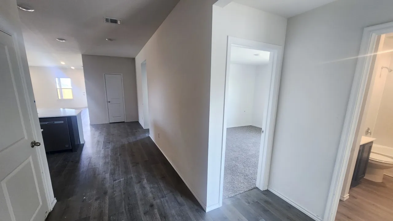 Interior hallway featuring wood-finish flooring, white walls, and recessed lighting