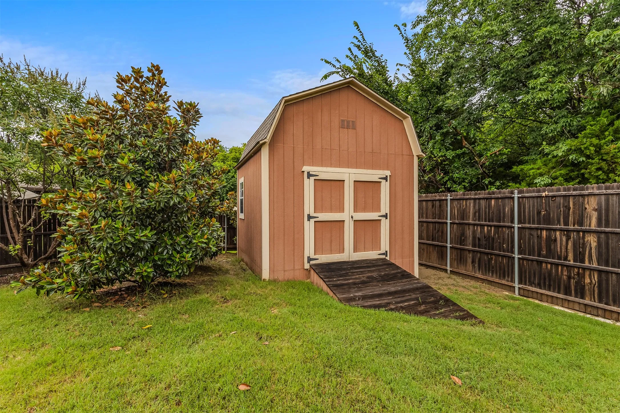 Craftsman Workshop, Freestanding outdoor shed with wood-finish siding, double doors, and an access ramp