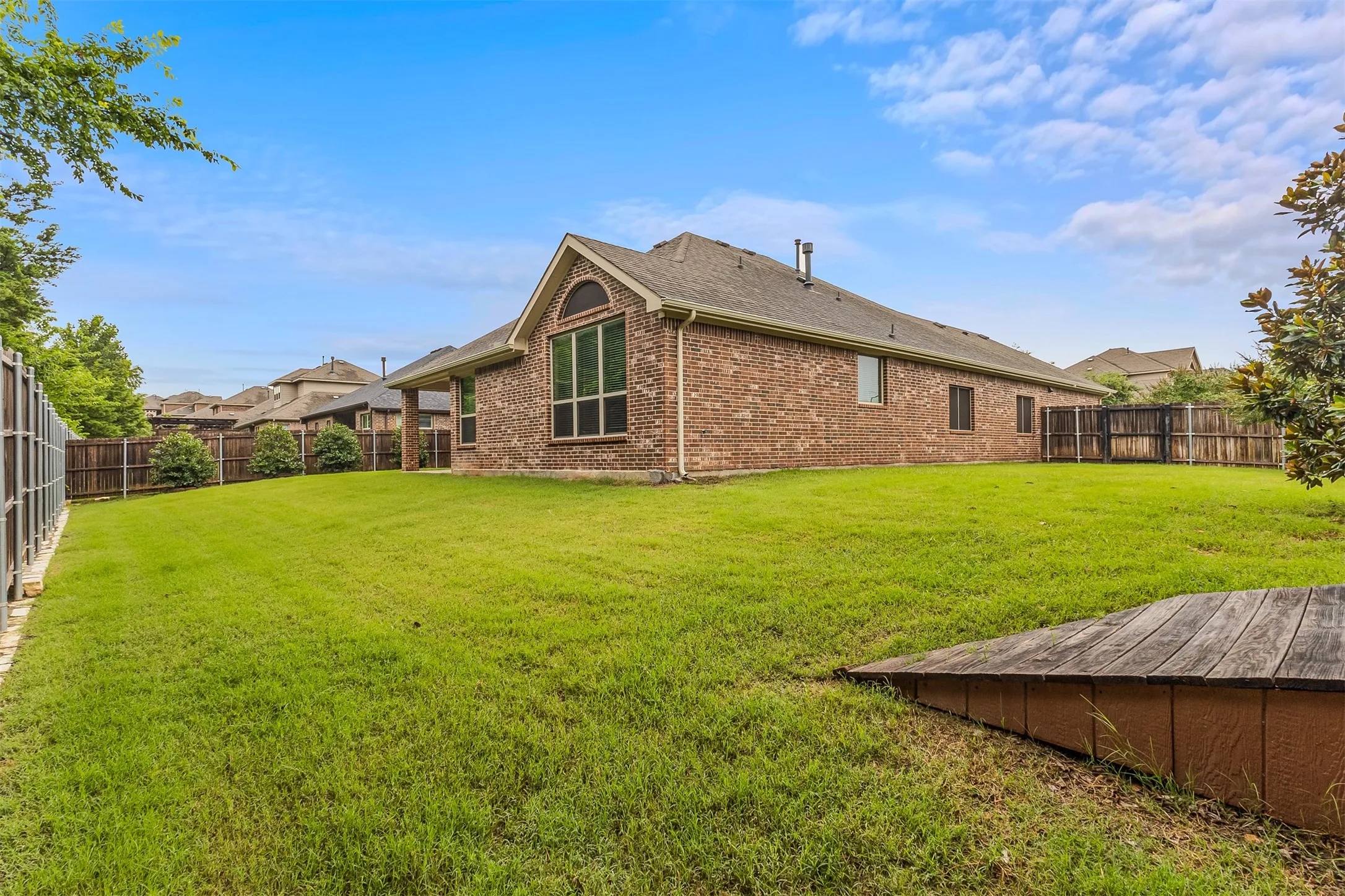 GREENBELT VIEWS Expansive backyard , and a manicured lawn, mature landscaping, and a wood privacy fence