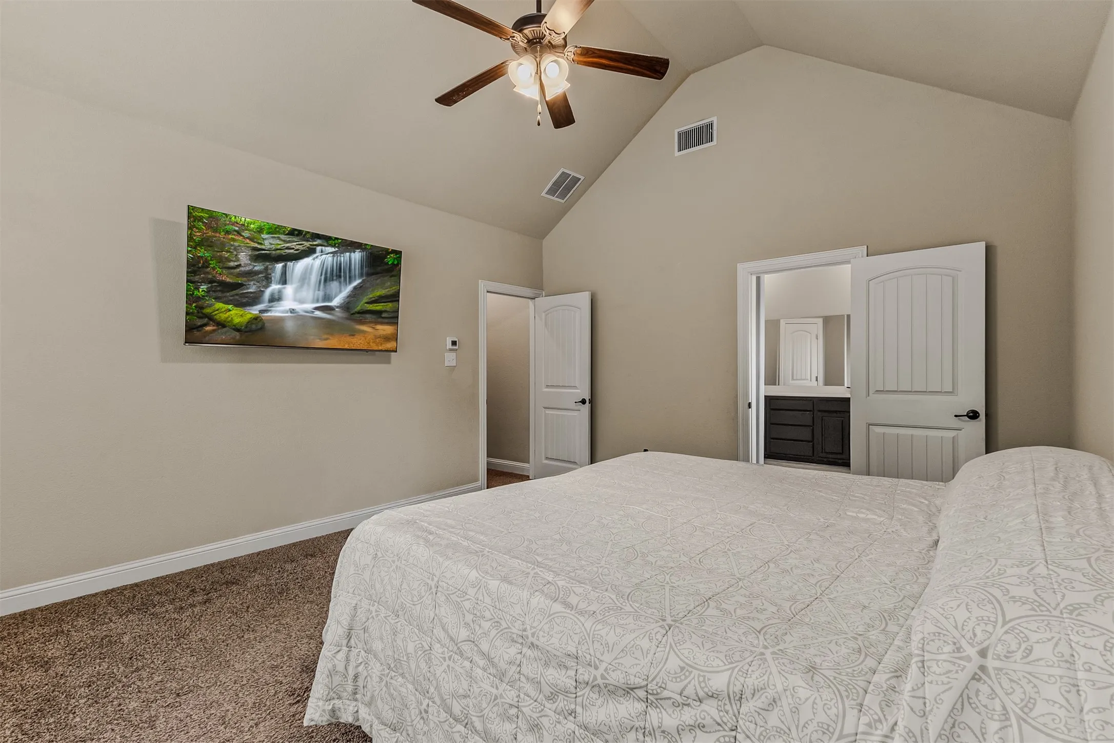 Vaulted ceiling room featuring a ceiling fan, carpet flooring, and white trim
