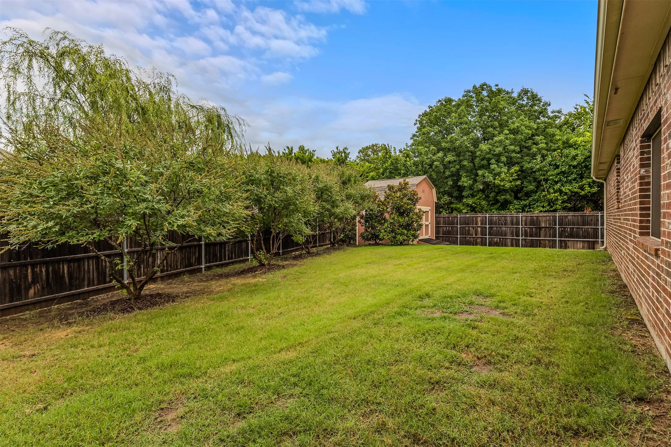 GORGEOUS GREENBELT. Expansive backyard featuring purple flowering vitex, and a manicured lawn, mature landscaping, and a wood privacy fence