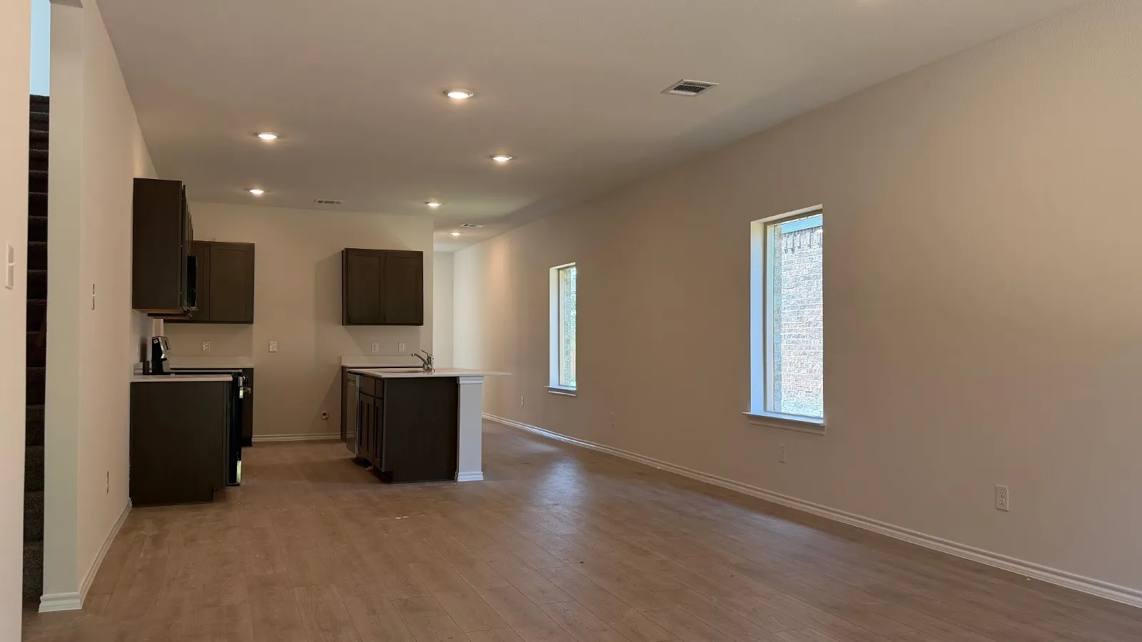 Open-concept living space featuring wood-finish flooring, recessed lighting, and neutral wall tones