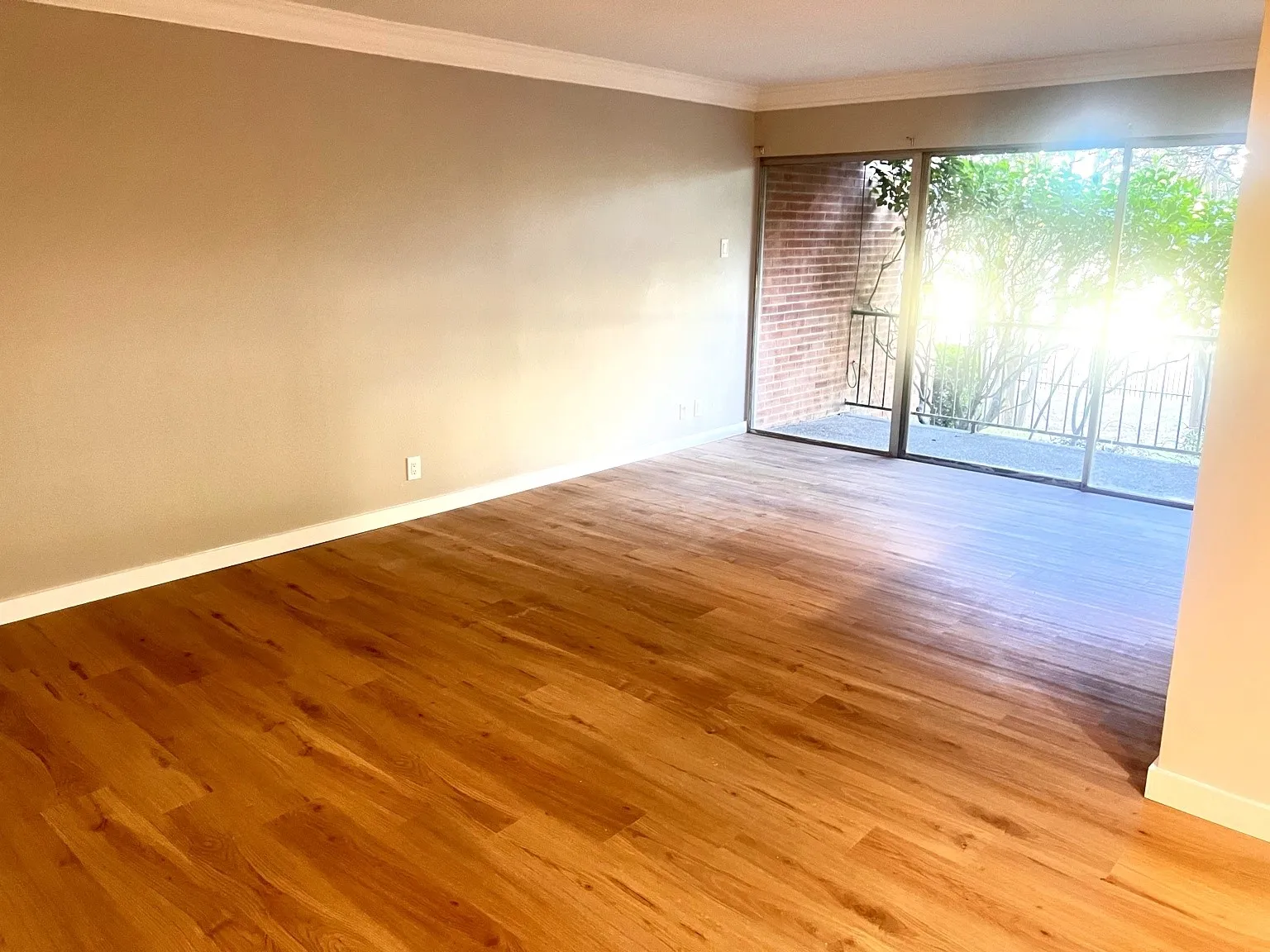 Spacious room featuring neutral-toned walls, and white crown molding.