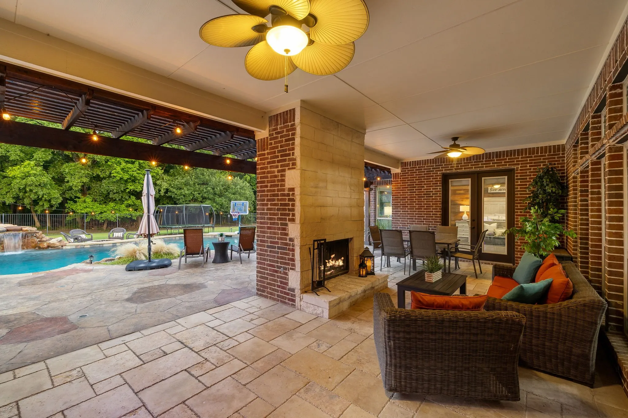 Covered backyard patio with fireplace and views for days