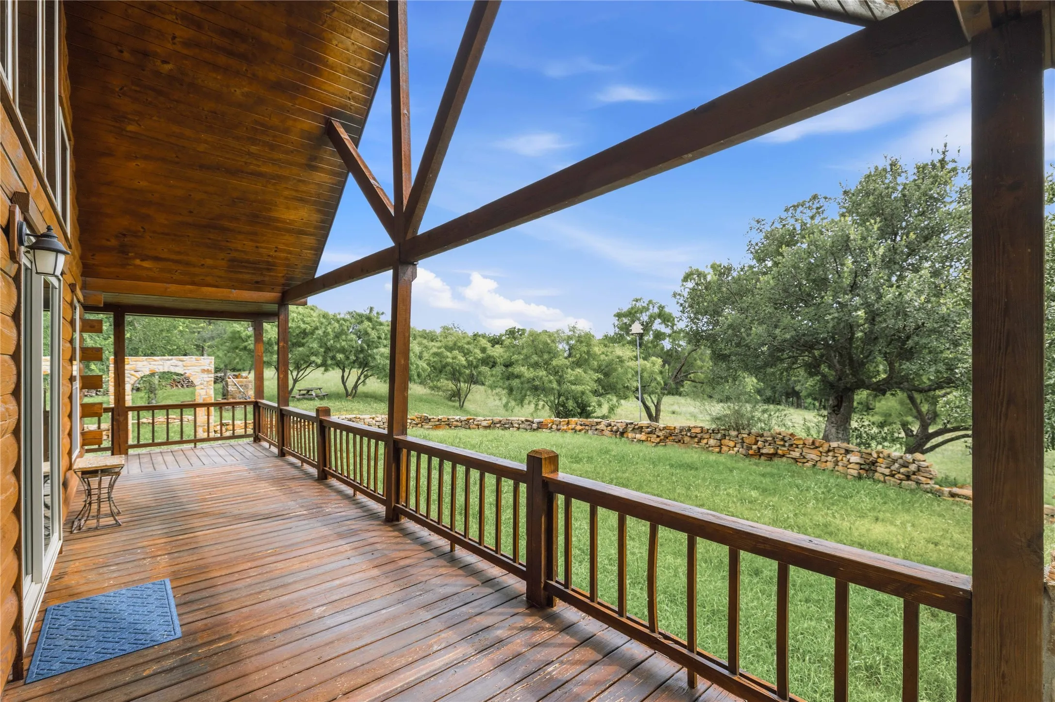 Spacious covered porch with wood-finish decking and railing
