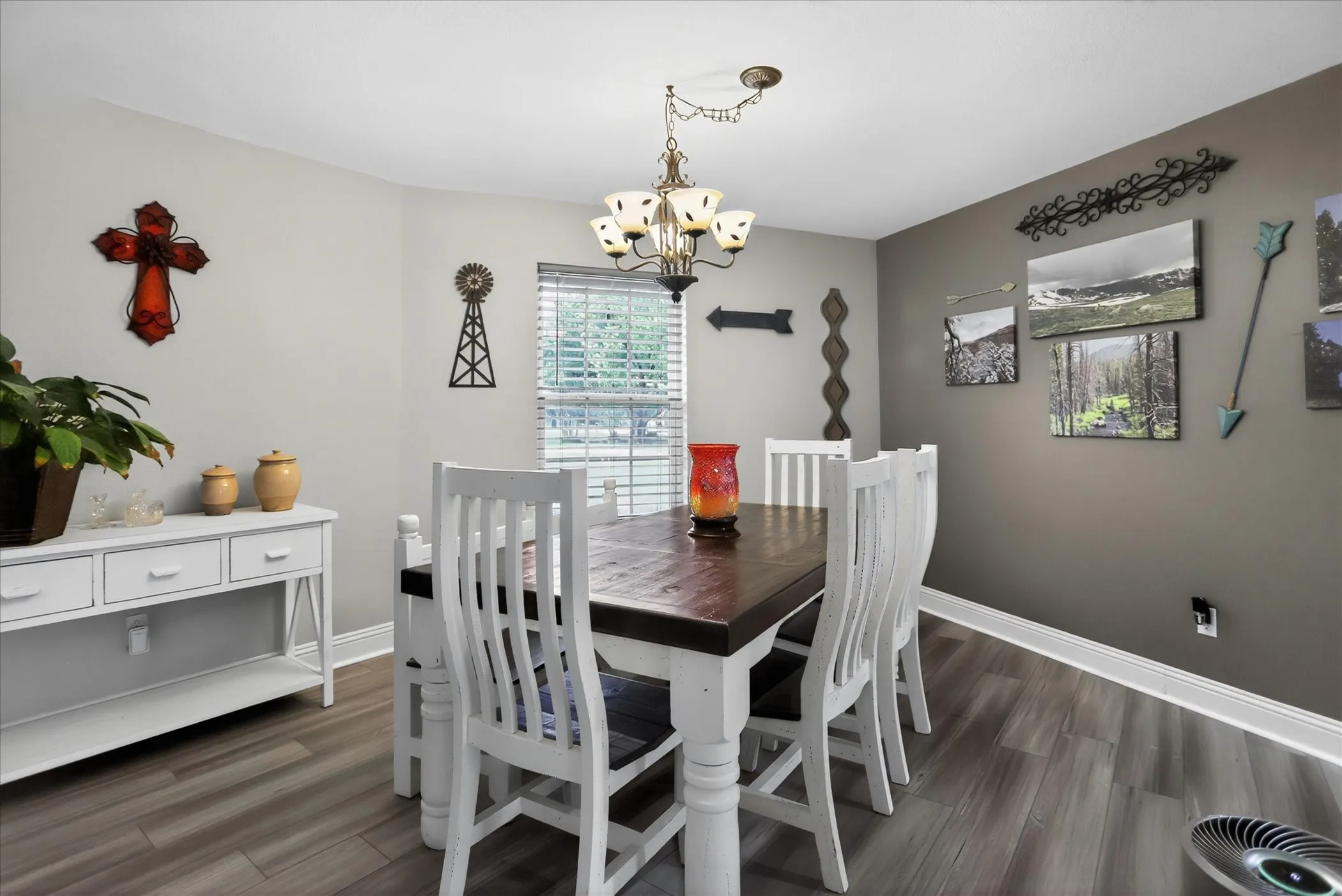 Dining room is bright with beautiful accent paint on wall.