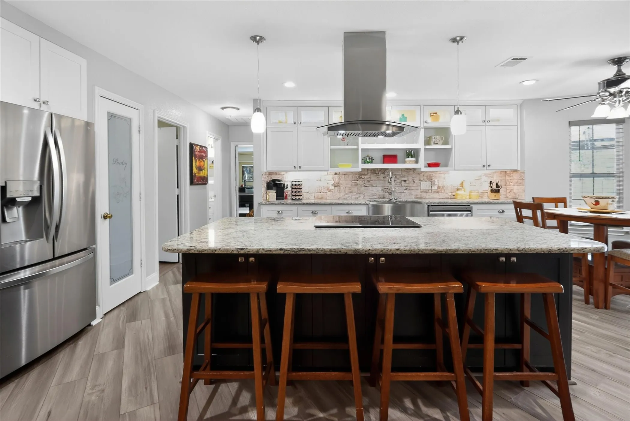 This open kitchen has an oversized island with seating for four. Deep farm style sink with a faucet that has a touch operating system.