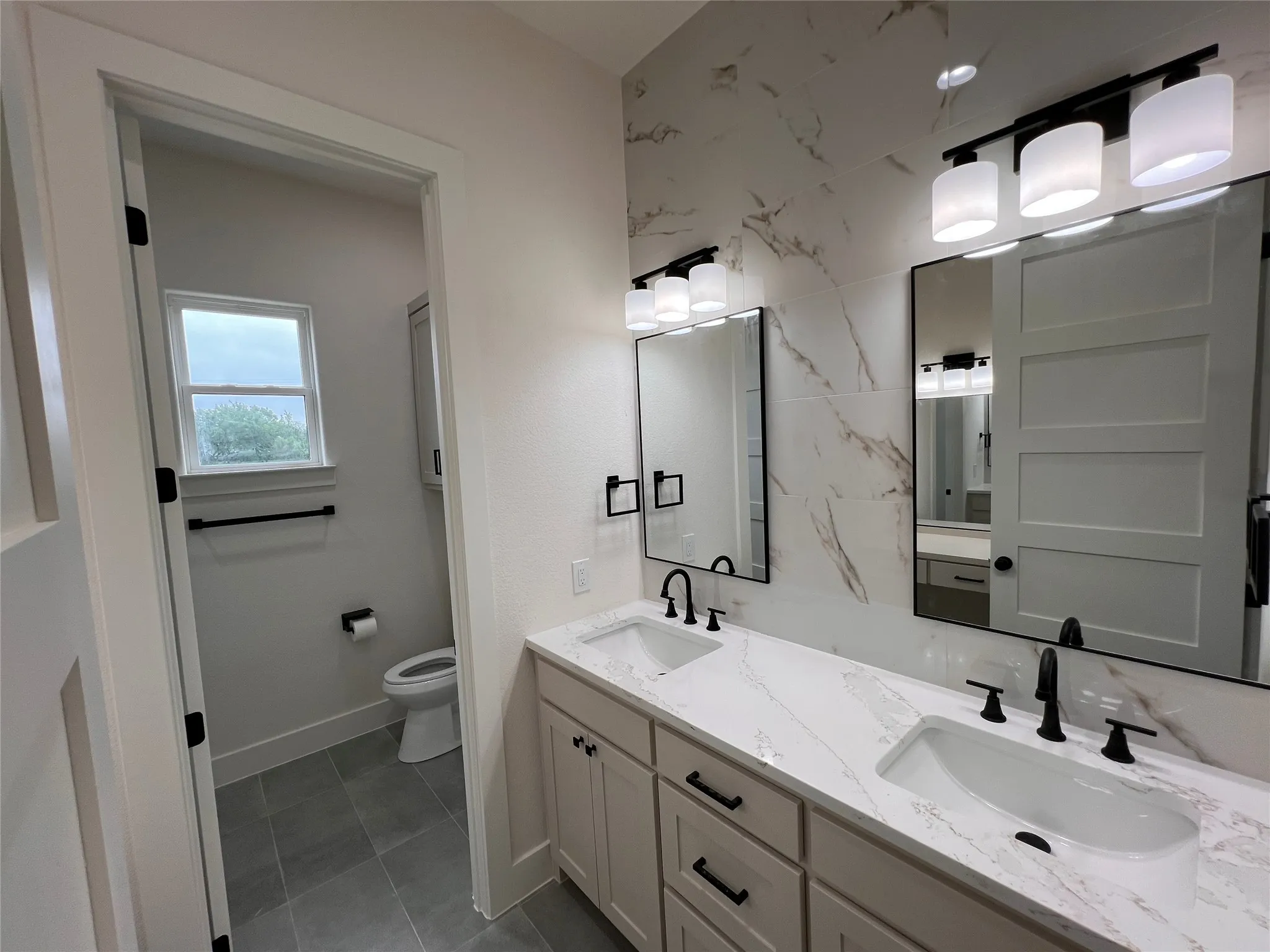 Dual vanity featuring white countertops, undermount sinks, and matte black fixtures
