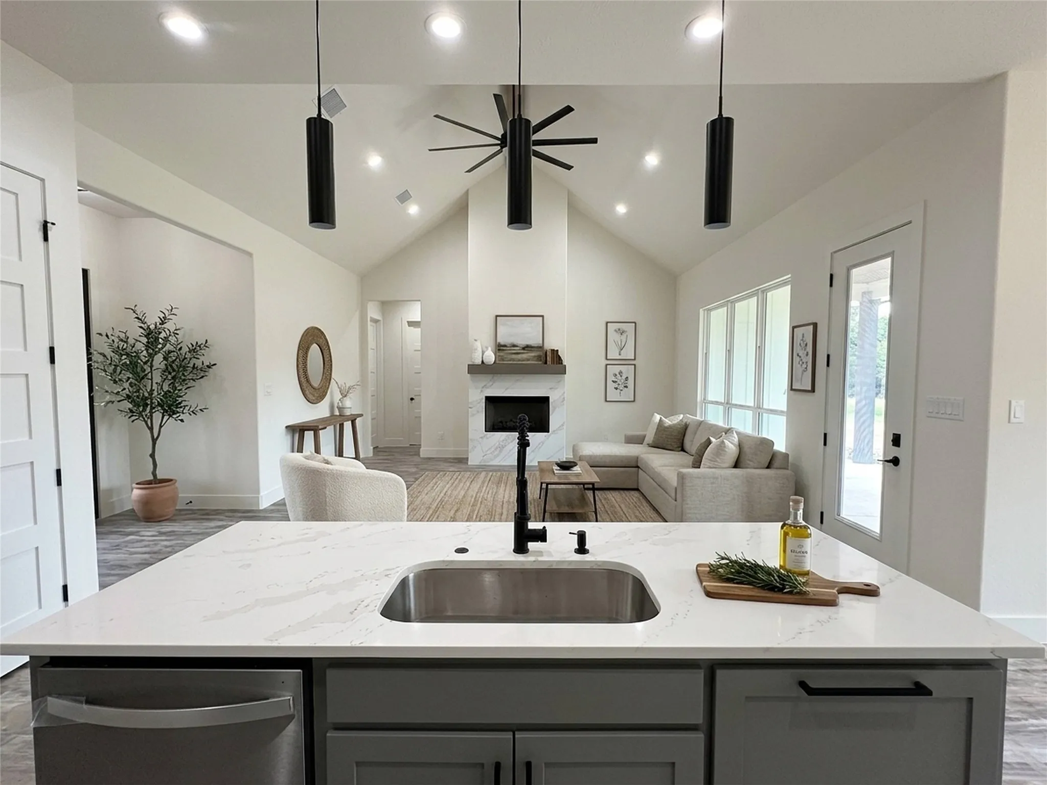 Kitchen island with a stainless steel undermount sink, a matte black faucet, and a light-toned countertop