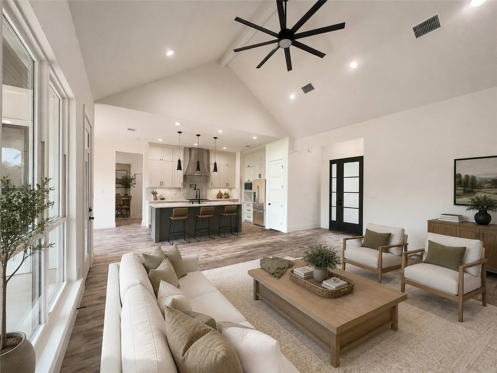 Open-concept living space featuring vaulted ceilings, recessed lighting, and wood-finish flooring