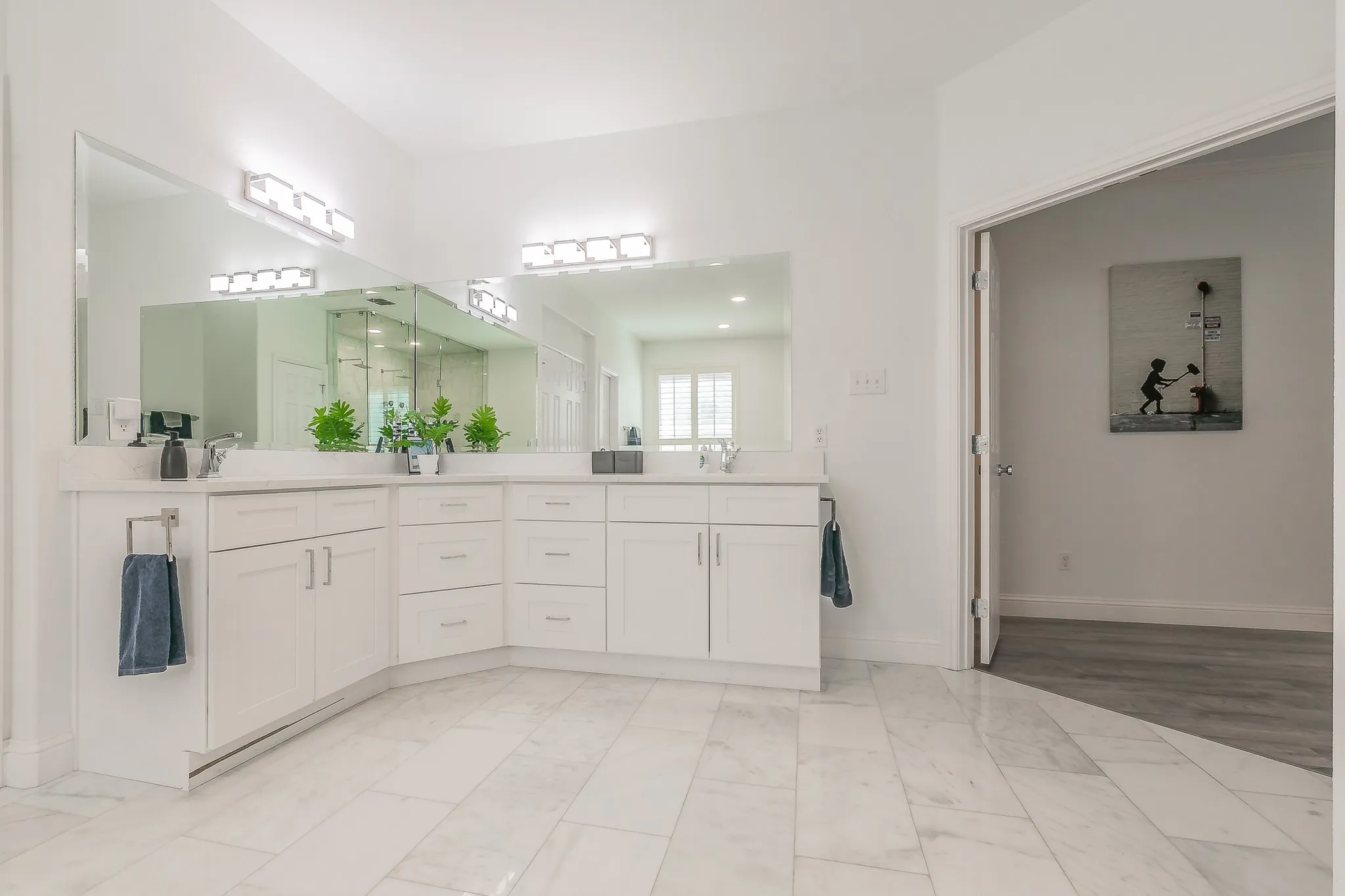 Bathroom featuring double vanity, marble finish floor, baseboards, and a sink