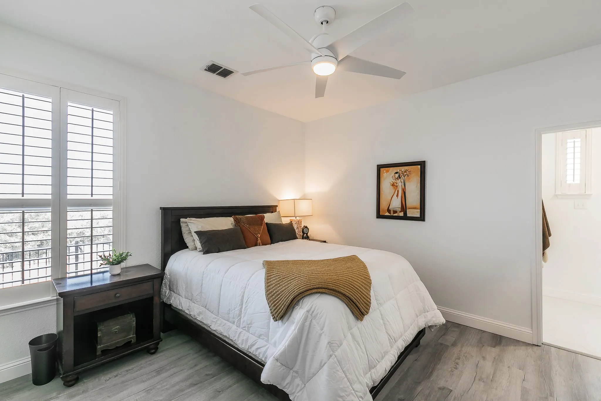 1st floor Bedroom with light wood-type flooring, visible vents, baseboards, and ceiling fan