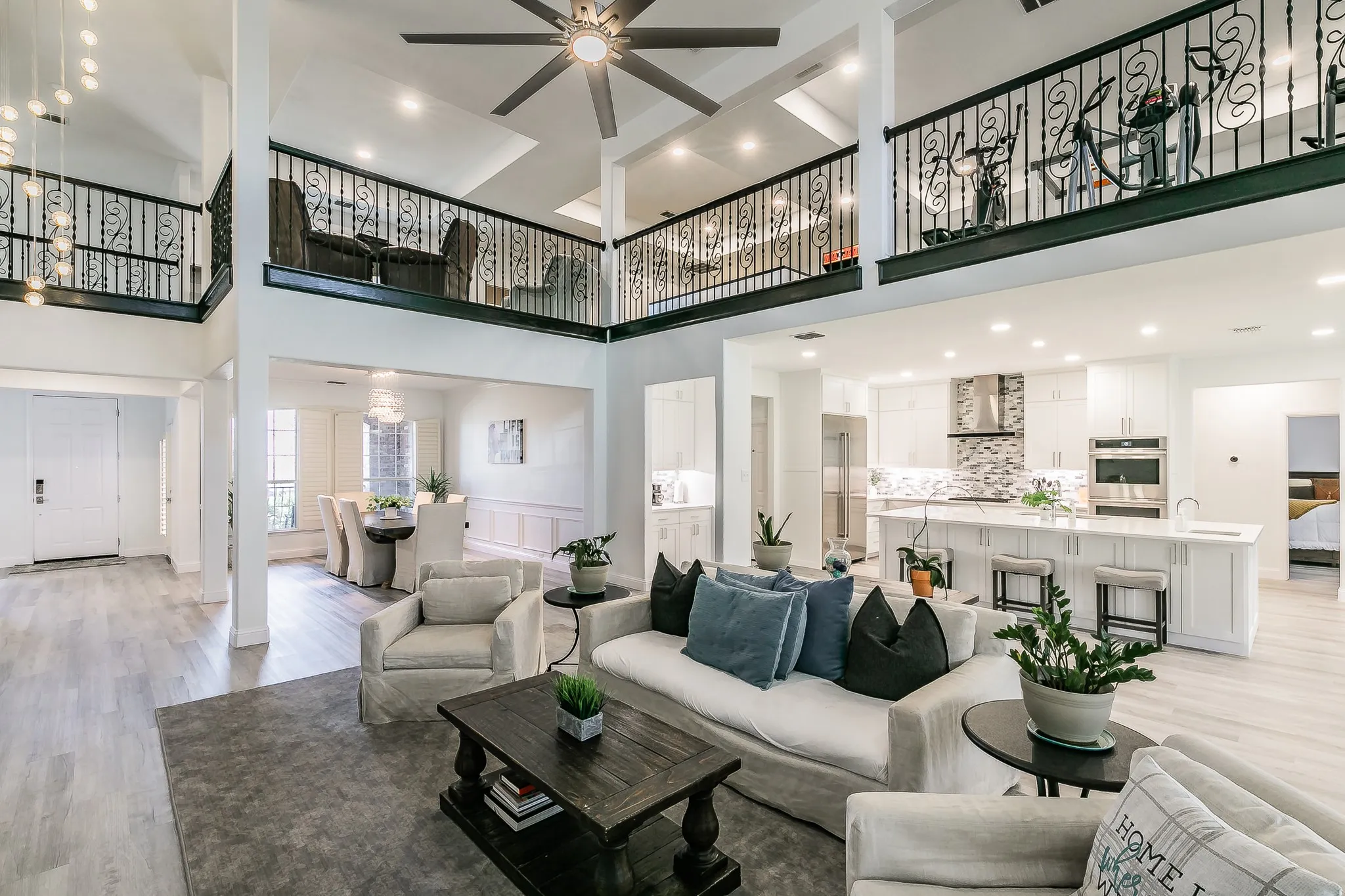 Living area with light wood-style floors and a towering ceiling
