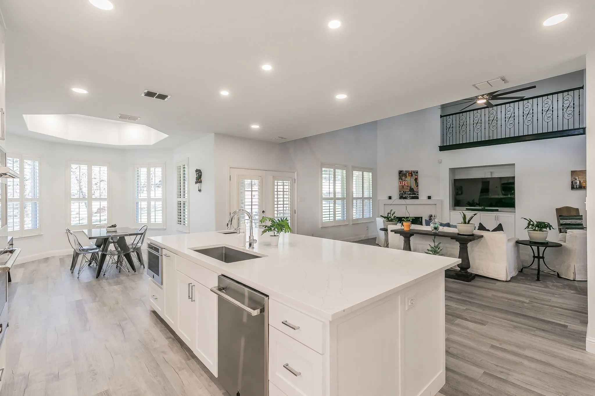 Kitchen featuring a sink, stainless steel dishwasher, white cabinetry, recessed lighting, and light wood-style floors