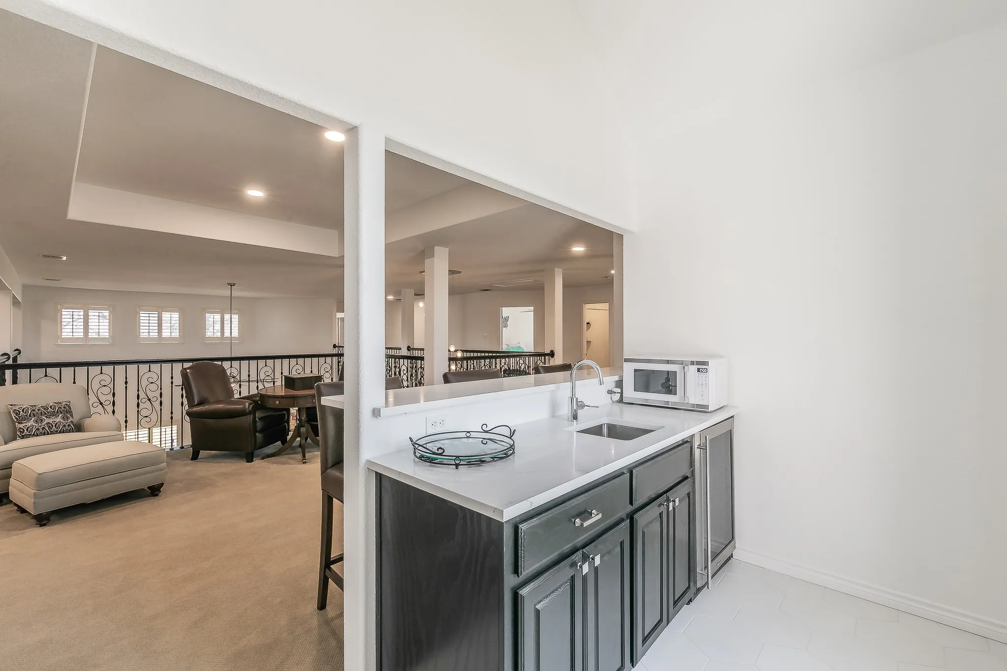 Kitchen featuring light countertops, white microwave, open floor plan, and a sink