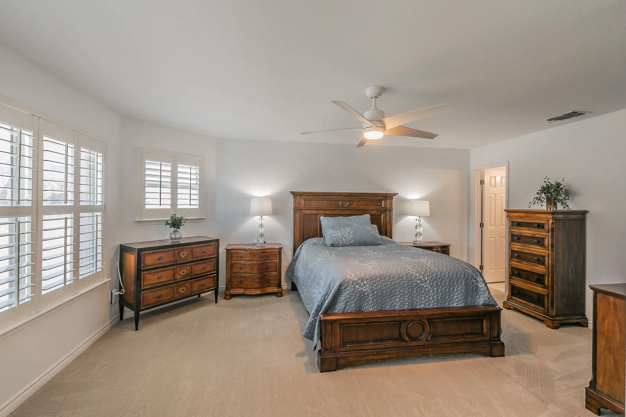Bedroom featuring visible vents, baseboards, carpet, and ceiling fan w/ ensuite bathroom attached. Could be a second primary.