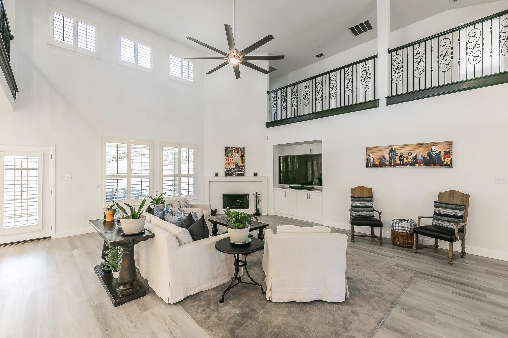 Living area with visible vents, baseboards, wood finished floors, and a ceiling fan