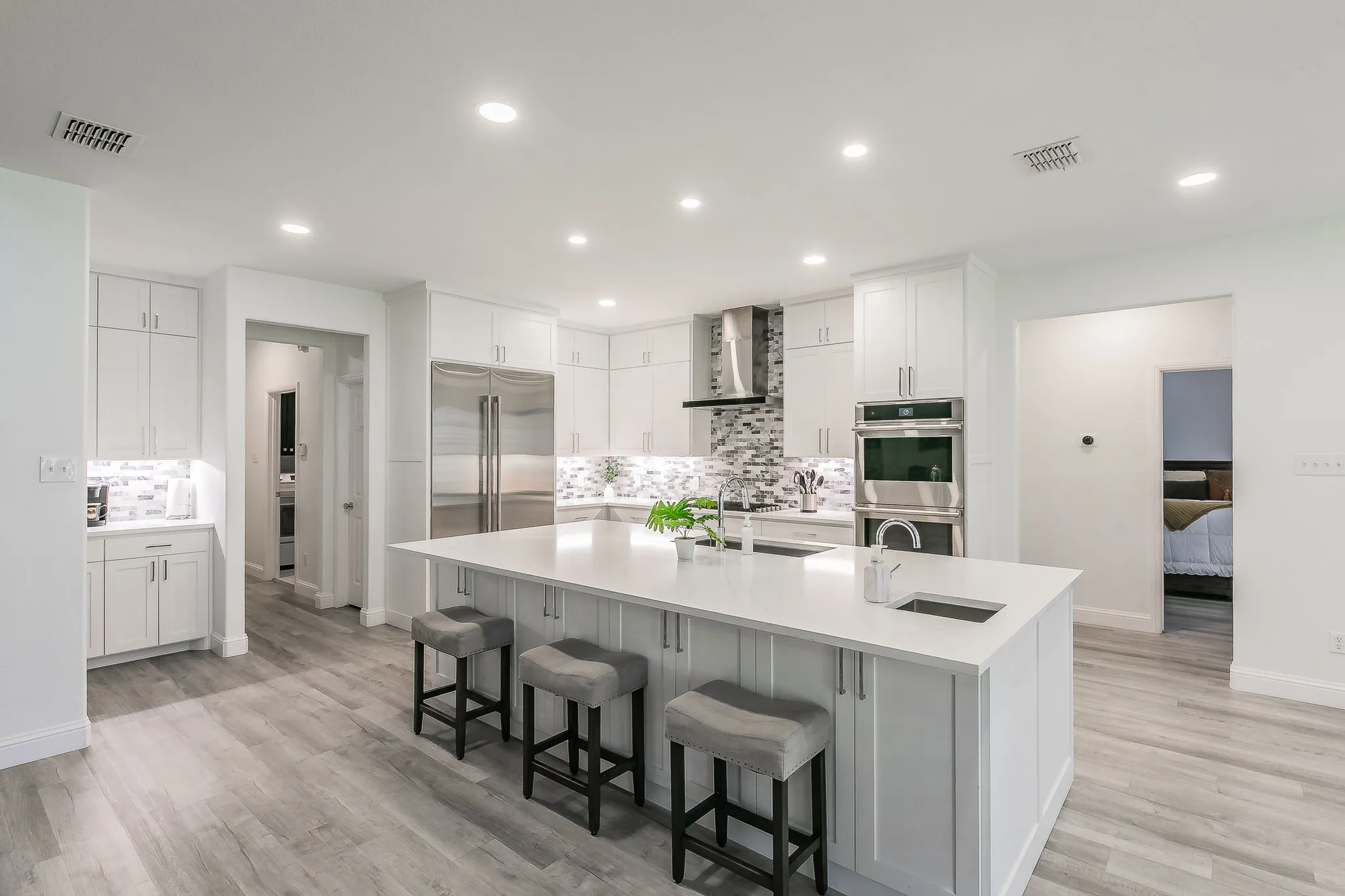 Kitchen with visible vents, appliances with stainless steel finishes, wall chimney range hood, and a sink