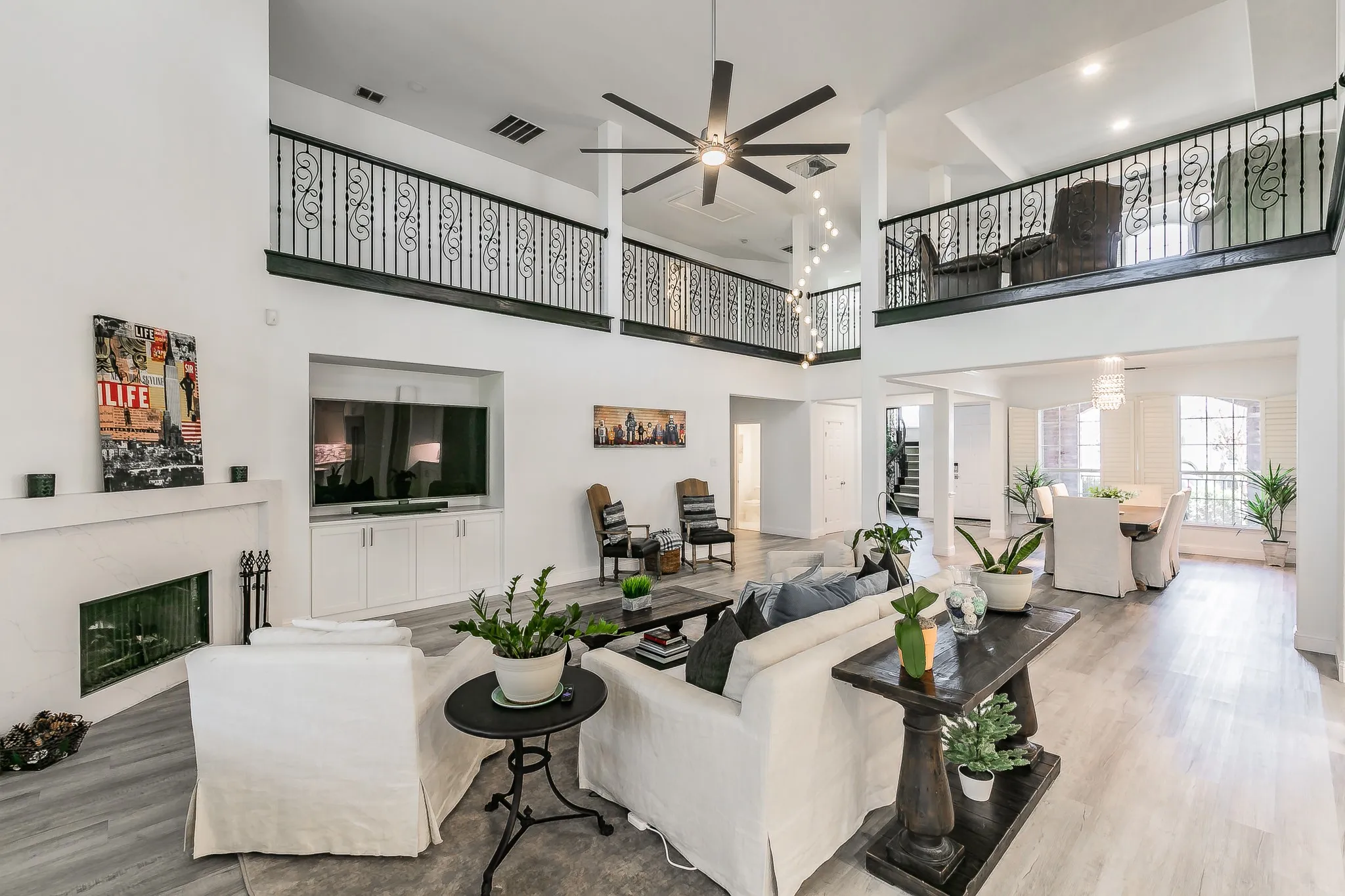 Living area with visible vents, a fireplace, a towering ceiling, and wood finished floors