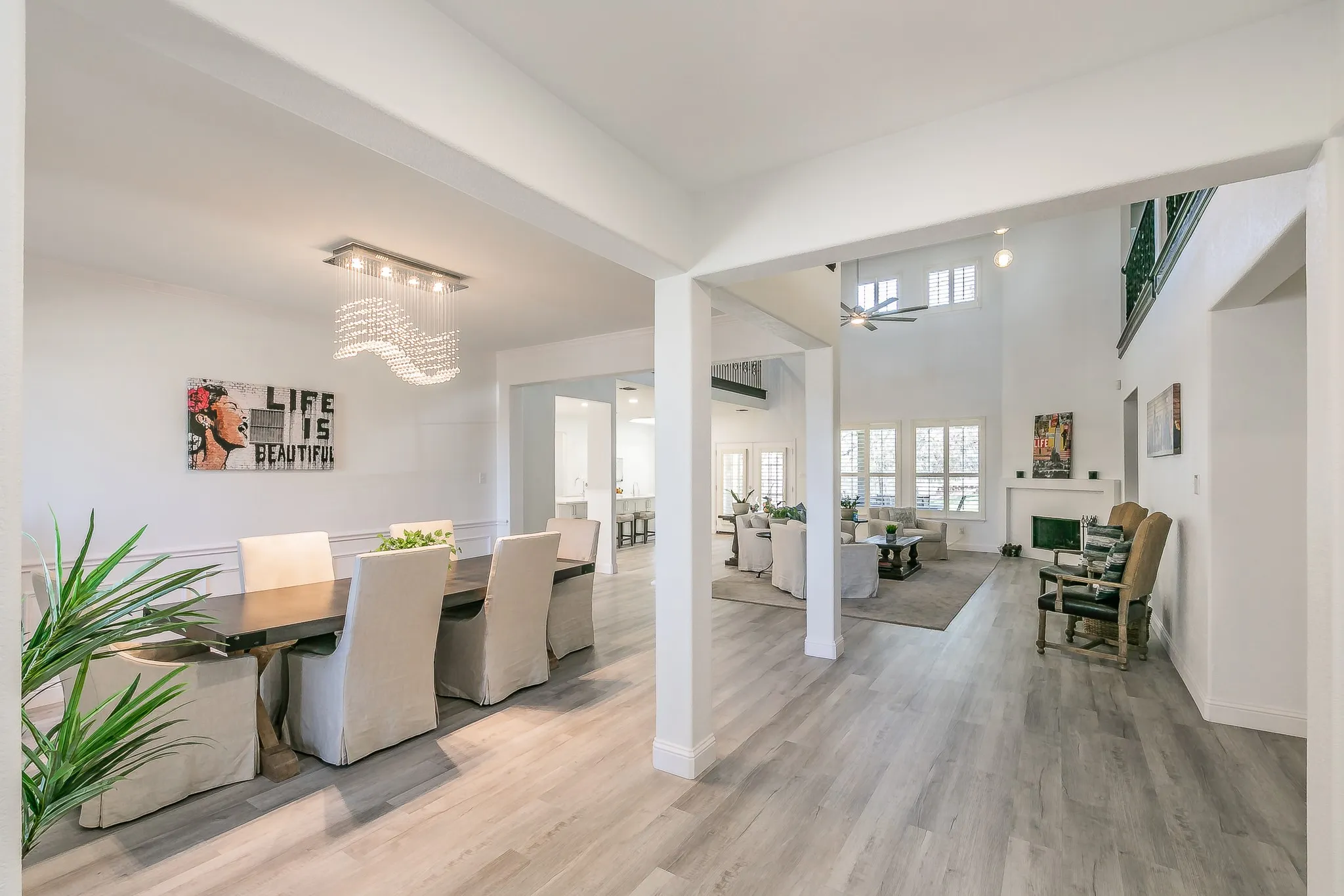Dining area featuring a towering ceiling, ceiling fan with notable chandelier, baseboards, and wood finished floors