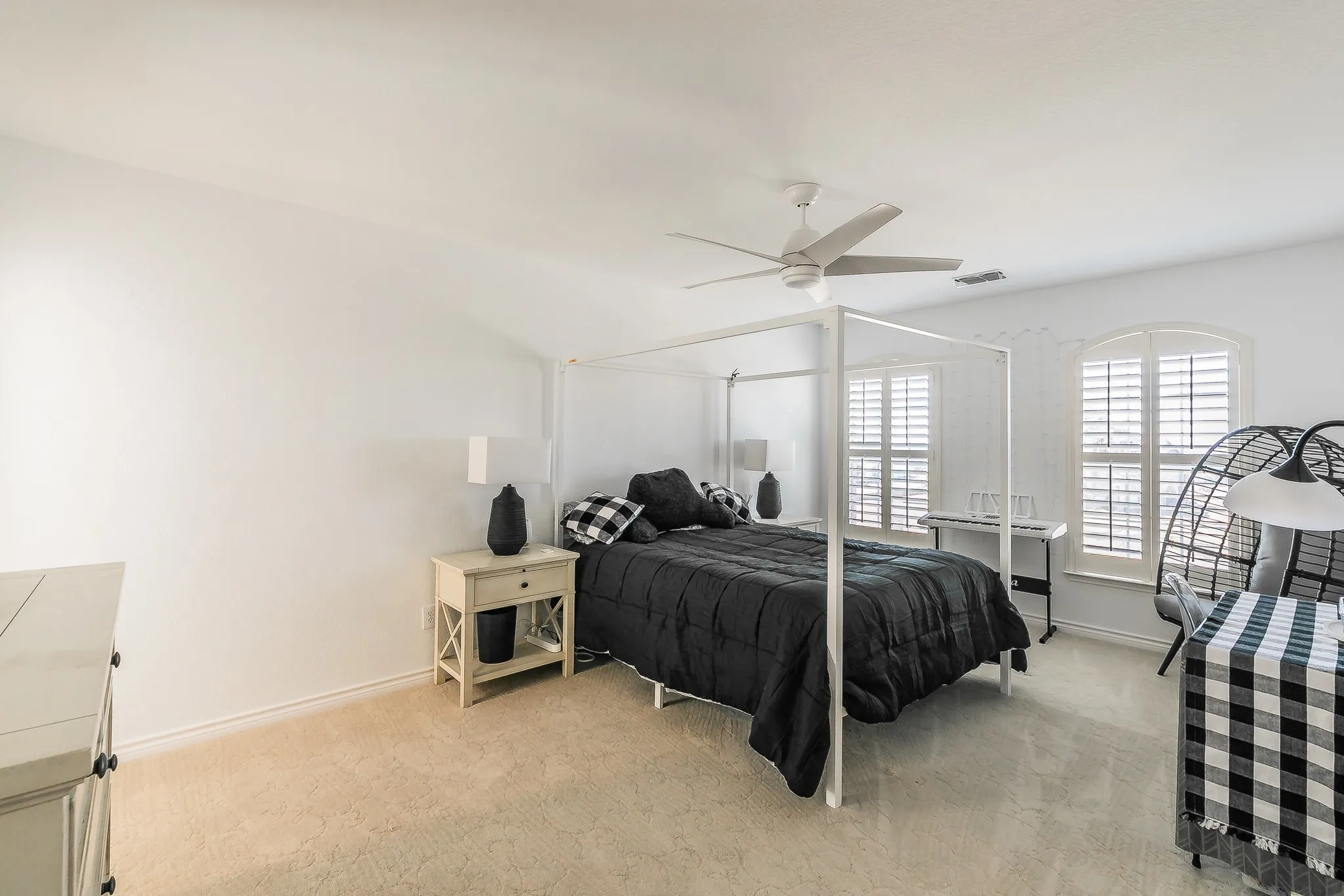 Bedroom with visible vents, light carpet, baseboards, and ceiling fan